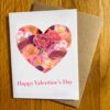 Botanical Valentine 1 Holiday Card with a heart filled with a collage of pink flowers on a white background. Below it is text reading "Happy Valentine's Day"