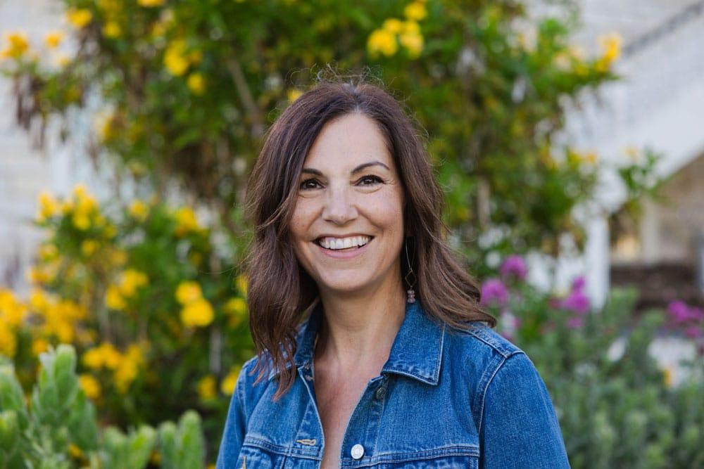 Portrait of smiling Erin Hunter, Biological Illustrator, in an outdoor setting and jean jacket