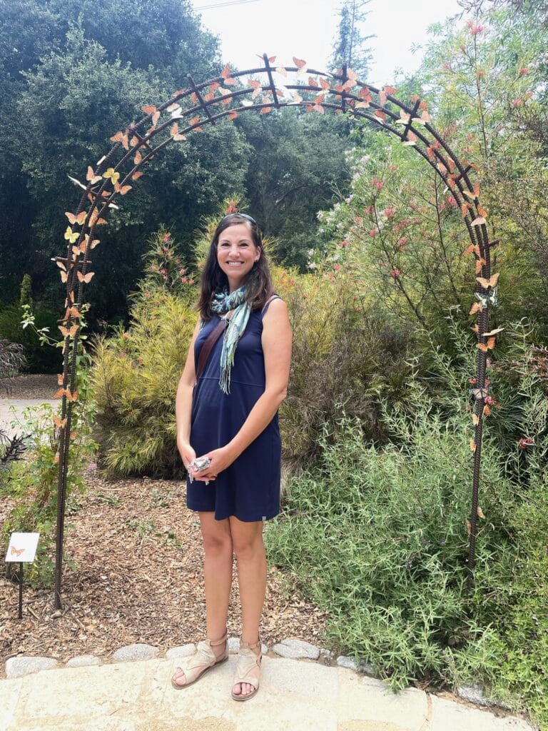 Erin at Descanso Gardens, standing next to a display of butterflies she helped create with exhibit designer Karina White.