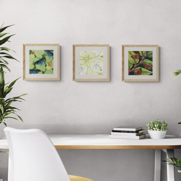 3 insect paintings shown above a desk workspace